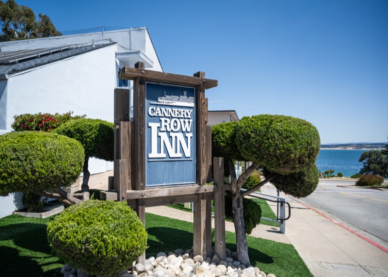 The inn's entrance sign and garden with the ocean visible down the street