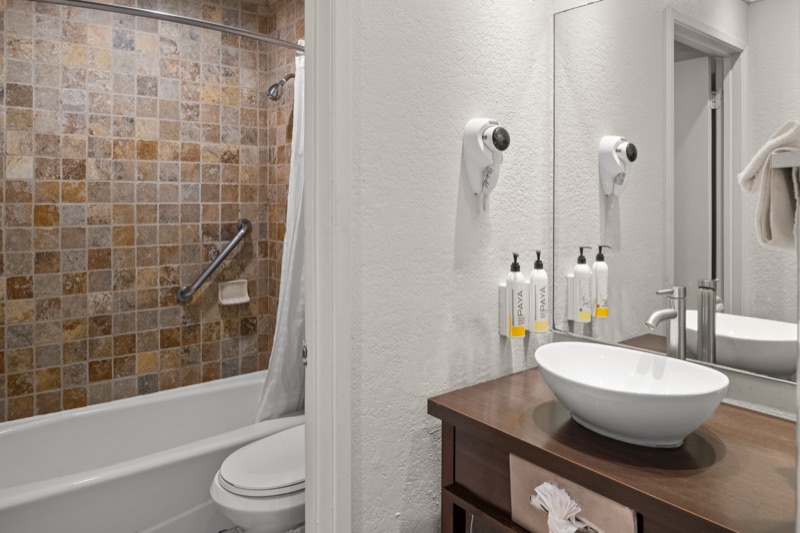 Guest bathroom with travertine shower and vessel sink