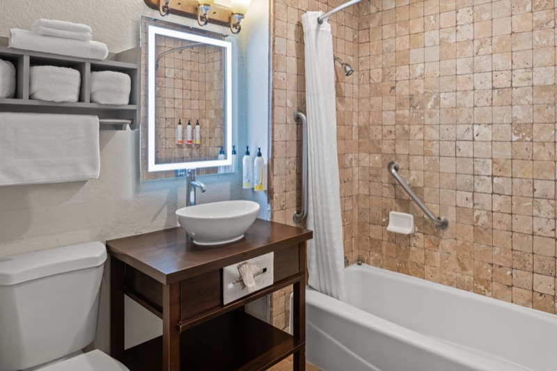Bathroom vanity with LED-lit mirror and white vessel sink