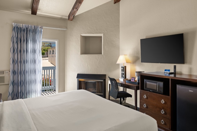King room with vaulted wood-beam ceiling and fireplace