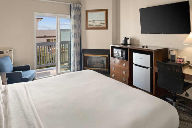 King room with fireplace and sliding door opening to a bay-view balcony